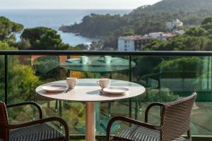 a table and chairs on a balcony with a view of the ocean at Albamar Apartaments in Lloret de Mar