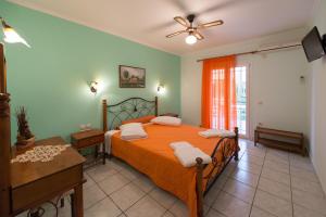 a bedroom with a bed with an orange bedspread at Kaspy Country Houses in Lygia