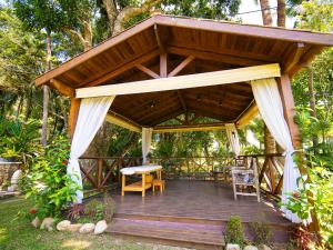 a wooden pavilion with a table and chairs on a deck at Velas do Engenho in Ilhabela