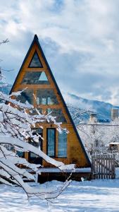 a house with a triangular roof in the snow at A-frame mestia in Mestia