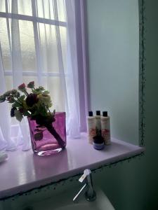 a vase of flowers sitting on a window sill at Number Two Russell House Tavistock Devon in Tavistock