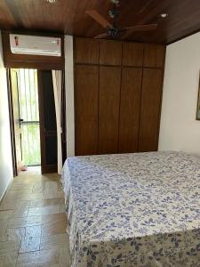 um quarto com uma cama e uma ventoinha de tecto em Quinta do Conde em Lauro de Freitas