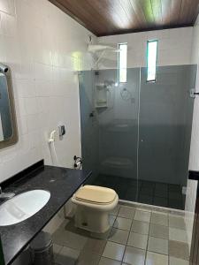 a bathroom with a shower and a toilet and a sink at Quinta do Conde in Lauro de Freitas