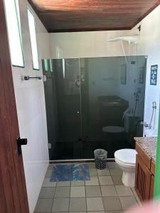 a bathroom with a glass shower and a toilet at Quinta do Conde in Lauro de Freitas