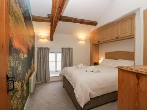 a bedroom with a large bed and a window at Taylor's Cottage in Keswick