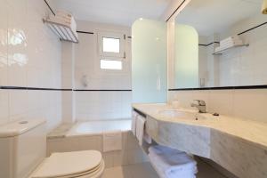 a bathroom with a sink and a toilet and a tub at Albamar Apartaments in Lloret de Mar