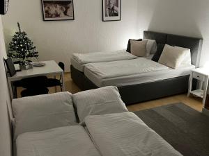 a living room with two beds and a christmas tree at Marilyn in Niederwil