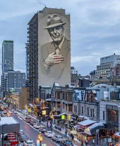 um grande cartaz de um homem com um chapéu num edifício em Stanley Court Apartments by Simplissimmo em Montreal