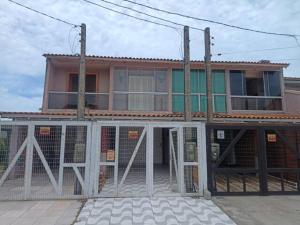 budynek z bramą przed nim w obiekcie Lindo Duplex à 50 metros da praia w mieście Imbé