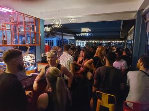 a crowd of people standing in a bar at Saigon Rooftops Hostel in Ho Chi Minh City