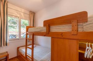 a bedroom with two bunk beds and a window at Albamar Apartaments in Lloret de Mar