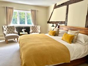 a large bedroom with a large bed and two chairs at The Manor at Abberley in Abberley