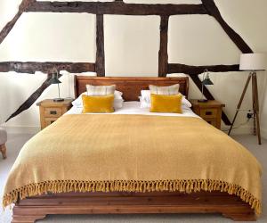 een slaapkamer met een groot houten bed met gele kussens bij The Manor at Abberley in Abberley