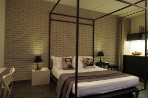 a bedroom with a bed and a brick wall at Terrazzani Suite in Comiso