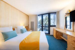 Cette chambre comprend un lit et une grande fenêtre. dans l'établissement Lake Hotel Courchevel 1850, à Courchevel