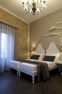 a bedroom with two beds and a chandelier at Terrazzani Suite in Comiso