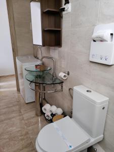 uma casa de banho com um WC e uma mesa de vidro em Mavros Gatos Apartments em Epanomi