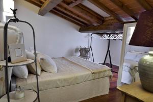 サン・カシャーノ・イン・ヴァル・ディ・ペーザにあるVilla Borri Country Suitesのベッドルーム1室(ベッド1台、ランプ付きテーブル付)