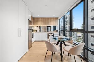 a kitchen and dining room with a glass table and chairs at New Stature Southbank Luxury in Melbourne