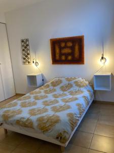 a bedroom with a bed and two lights on the wall at La Rosaire in Soulac-sur-Mer