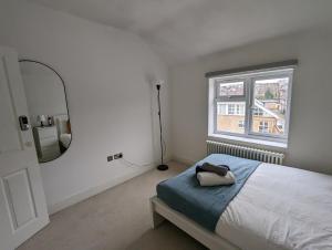 a white bedroom with a bed and a mirror at Super 1 bedroom in a stunning apartment with shared kitchen and living room - 2C The Charteris in London