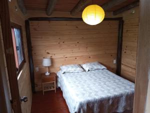 ein Schlafzimmer mit einem Bett in einer Holzhütte in der Unterkunft Sietevestidos Casa Ecológica - Punta Negra in Punta Colorada
