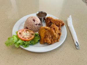 un plato de comida con pollo y tomate en una mesa en Toby's Resort, en Montego Bay