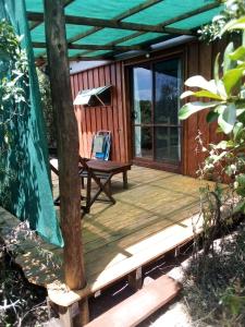 una terraza de madera con una silla encima en Sietevestidos Casa Ecológica - Punta Negra en Punta Colorada