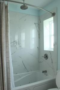 a white bathroom with a shower and a bath tub at Relax and Enjoy Bayou Grande in Pensacola