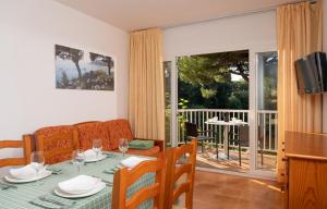 Albamar Apartaments في يوريت دي مار: غرفة معيشة مع طاولة وأريكة