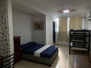 a bedroom with a blue bed and a chair at Alojamientos Cartagena Edificio Los Delfines in Cartagena de Indias