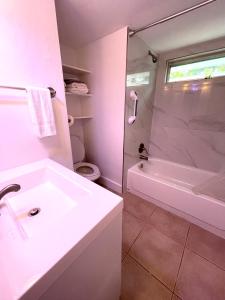 ein Badezimmer mit einem weißen Waschbecken und einer Dusche in der Unterkunft Downtown FTL apartments on the River in Fort Lauderdale