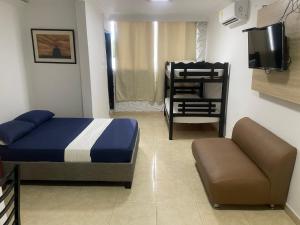 um quarto com uma cama, um sofá e uma televisão em Alojamientos Cartagena Edificio Los Delfines em Cartagena das Índias