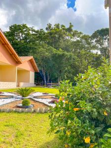 a garden with a pond in front of a house at Pousada Flores do Campo in Águas de Lindoia