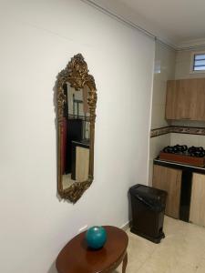 un espejo en la pared en una cocina con mesa en Alojamientos Cartagena Edificio Los Delfines, en Cartagena de Indias