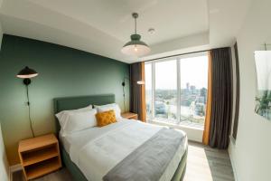 1 dormitorio con cama y ventana grande en The Laundry Rooms Station Park Kitchener en Kitchener