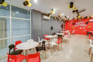 a restaurant with white tables and red chairs at JPS DELIGHT HOTEL in New Delhi