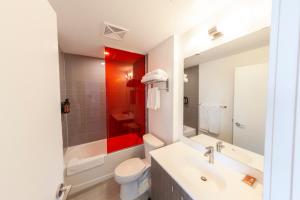 a bathroom with a sink and a toilet and a tub at The Laundry Rooms Station Park Kitchener in Kitchener +36 photos