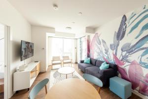 a living room with a couch and a table at The Laundry Rooms Station Park Kitchener in Kitchener