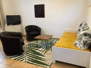 スラック・シュル・メールにあるLa Rosaireの椅子2脚、テーブル、テレビが備わる客室です。