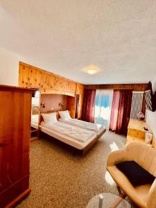 Hotel Old JNN في Klosters Serneus: غرفة نوم كبيرة بسريرين واريكة