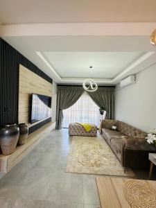 ハボローネにあるLux Villa Saronaのソファと薄型テレビのあるリビングルーム