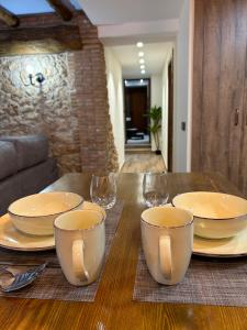 a wooden table with plates and wine glasses on it at Apartamento Peña Cortada in Alhama de Aragón