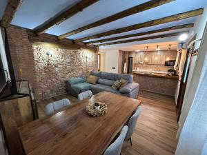 ein Wohnzimmer mit einem Holztisch und einer Couch in der Unterkunft Apartamento Peña Cortada in Alhama de Aragón