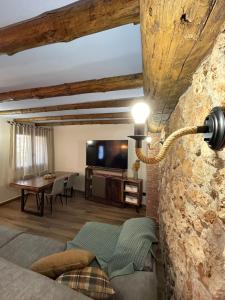 a bedroom with a stone wall with a tv and a table at Apartamento Peña Cortada in Alhama de Aragón