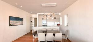 ein Esszimmer und eine Küche mit einem Tisch und Stühlen in der Unterkunft BnBIsrael apartments - Hayarkon Emeraude in Tel Aviv