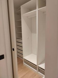 a white walk in closet with a glass door at New Nordic 2BR: Beach & Forest, Family-Friendly in Tallinn