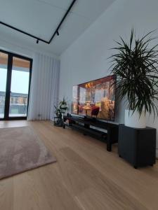 a living room with a large flat screen tv at New Nordic 2BR: Beach & Forest, Family-Friendly in Tallinn