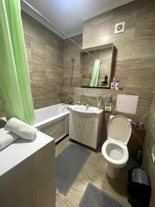 ein Badezimmer mit einem WC, einer Badewanne und einem Waschbecken in der Unterkunft Уютная квартира в верхней части города in Almaty
