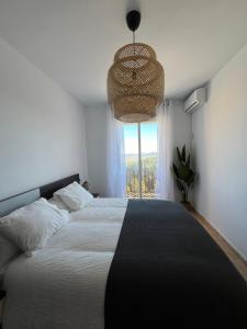 um quarto com uma cama grande e uma janela em El Mirador de Velez Blanco em Vélez Blanco